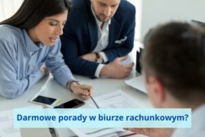 Kobieta w niebieskiej koszuli tłumaczy coś w dokumentach dwóm mężczyznom. Na stole leżą dokumenty i komórki.