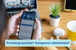 Dłonie z komórką w ręku. Na ekranie Facebook.